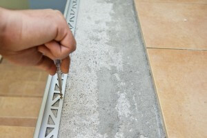 Securing aluminum tile eding with screws
